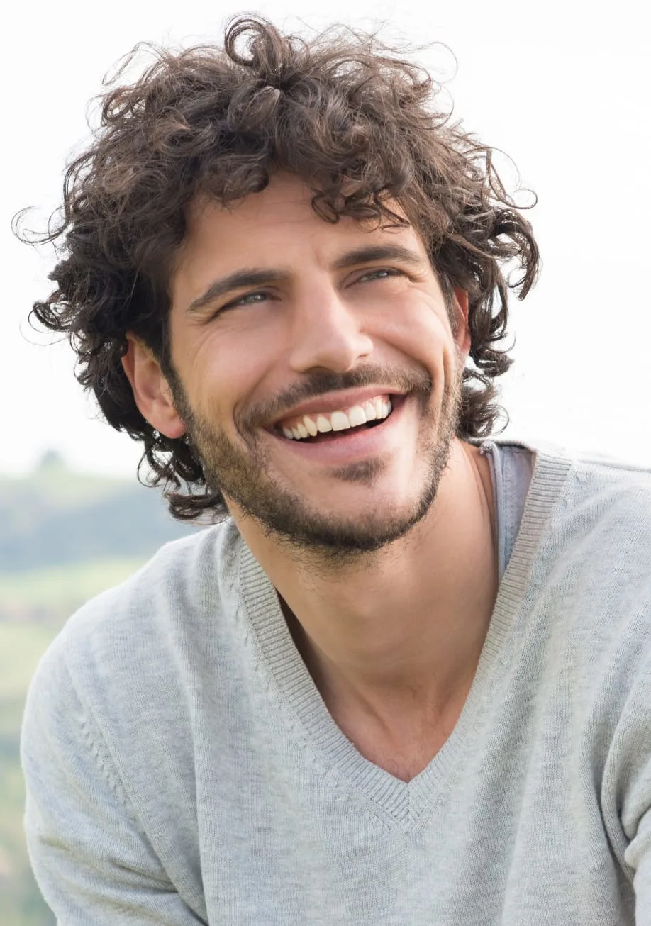 man with curly hair smiling
